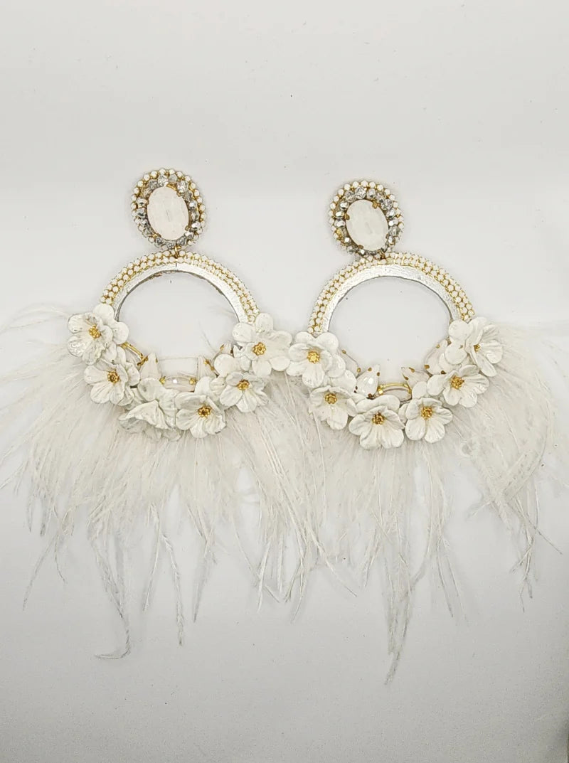 Handcrafted Silver Totumo Earrings: Featuring Double Crescent Moon Design adorned with Delicate White Banana Fiber Flowers with Golden Accents, embellished with White and Gold Gemstones, and adorned with Delicate Feathers cascading from the flowers.
