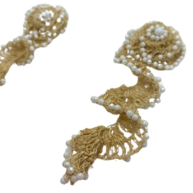 These stunning earrings feature a flower base with a lightning bolt shape above, symbolizing the power and softness of God's natural beauty and His Creation. Handmade with natural banana tree fibers, they are beautifully adorned with Murano stones around the flower base, creating a striking and unique design.