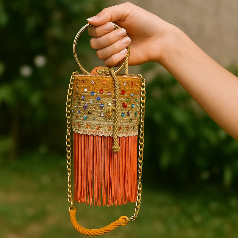 This Stones Mix Bucket Bag is stylish and fun. It features Murano stones all around and gold-tone strap hardware. The design is great for nighttime use at events. Soft fringe at the bottom adds movement. Made with sustainable banana tree fibers.