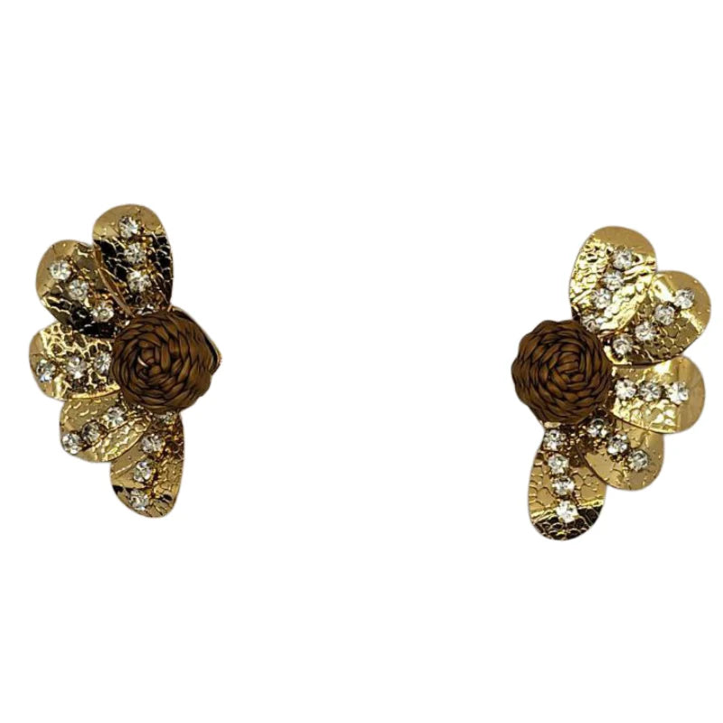 This stunning brooch showcases an elegant floral design, featuring shimmering golden petals with intricate hammered textures and dazzling crystal accents. At its center lies a beautifully woven banana fiber sphere, adding a natural, artisanal touch that contrasts gracefully with the metallic brilliance.