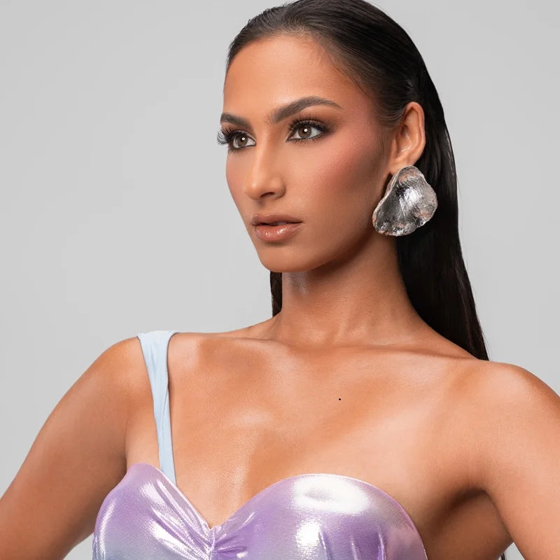 Featuring an organic, irregular silhouette and a polished metallic finish, these statement earrings bring contemporary elegance and artistic style to any outfit.