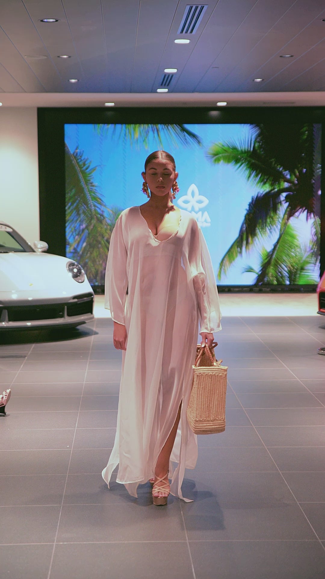 Model walking with the Enea Leather Beach Bag, showing its handcrafted design, leather details, and lightweight movement in a fashion show setting
