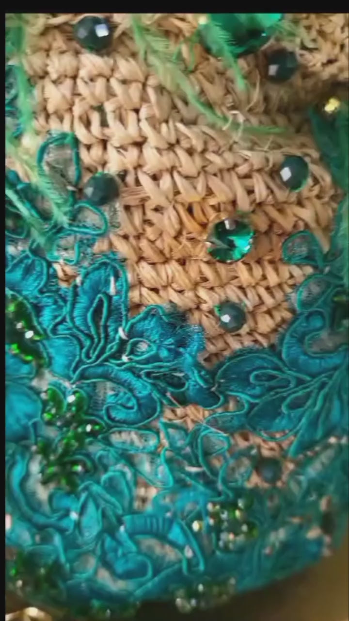 Video showcasing a green feather bucket bag with lace embroidery, gemstone details, and gold chain straps, highlighting its craftsmanship and movement.