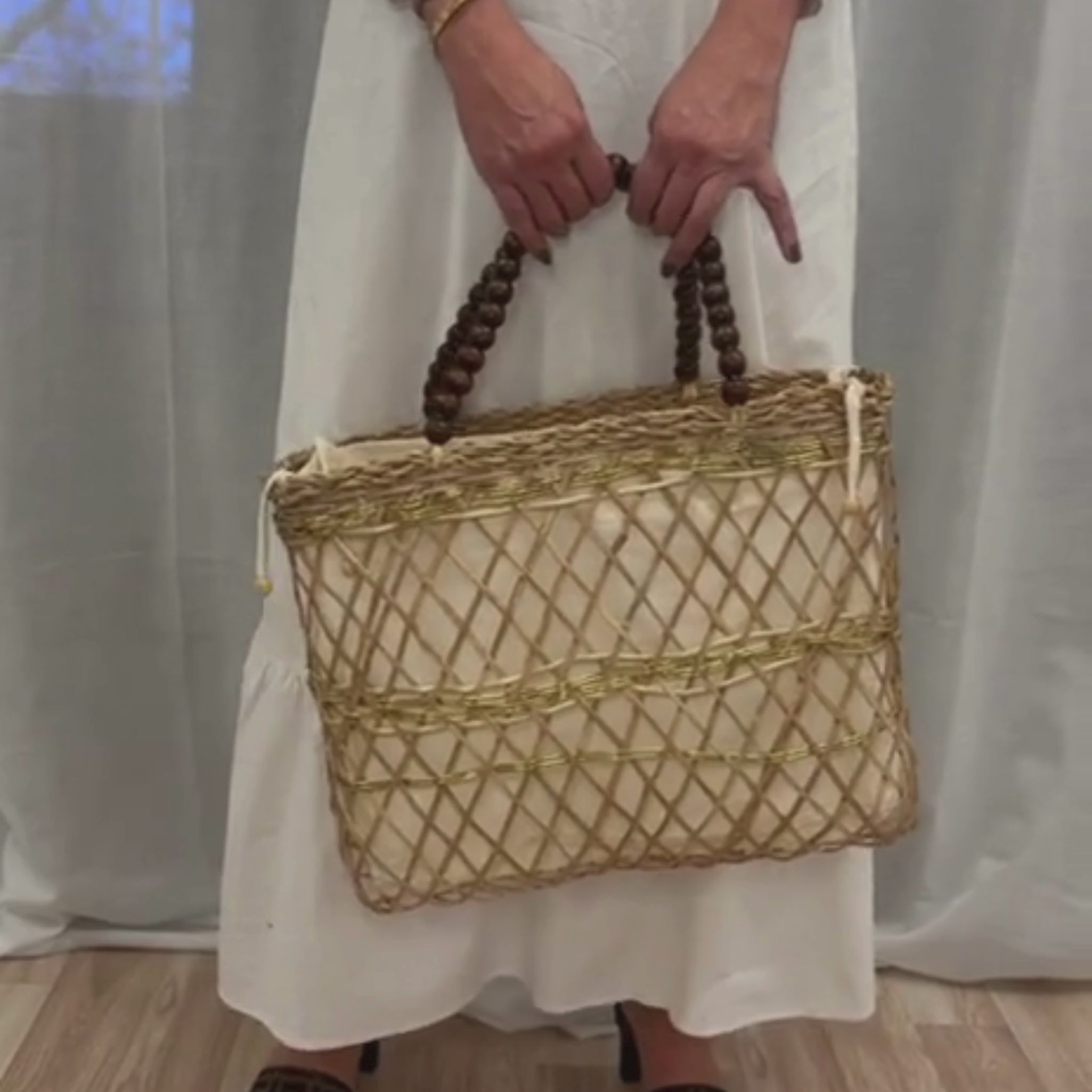 Handcrafted Bejuco & Macrame Gold Handbag in motion, showcasing banana fiber texture, gold macrame detailing, and natural wood handles