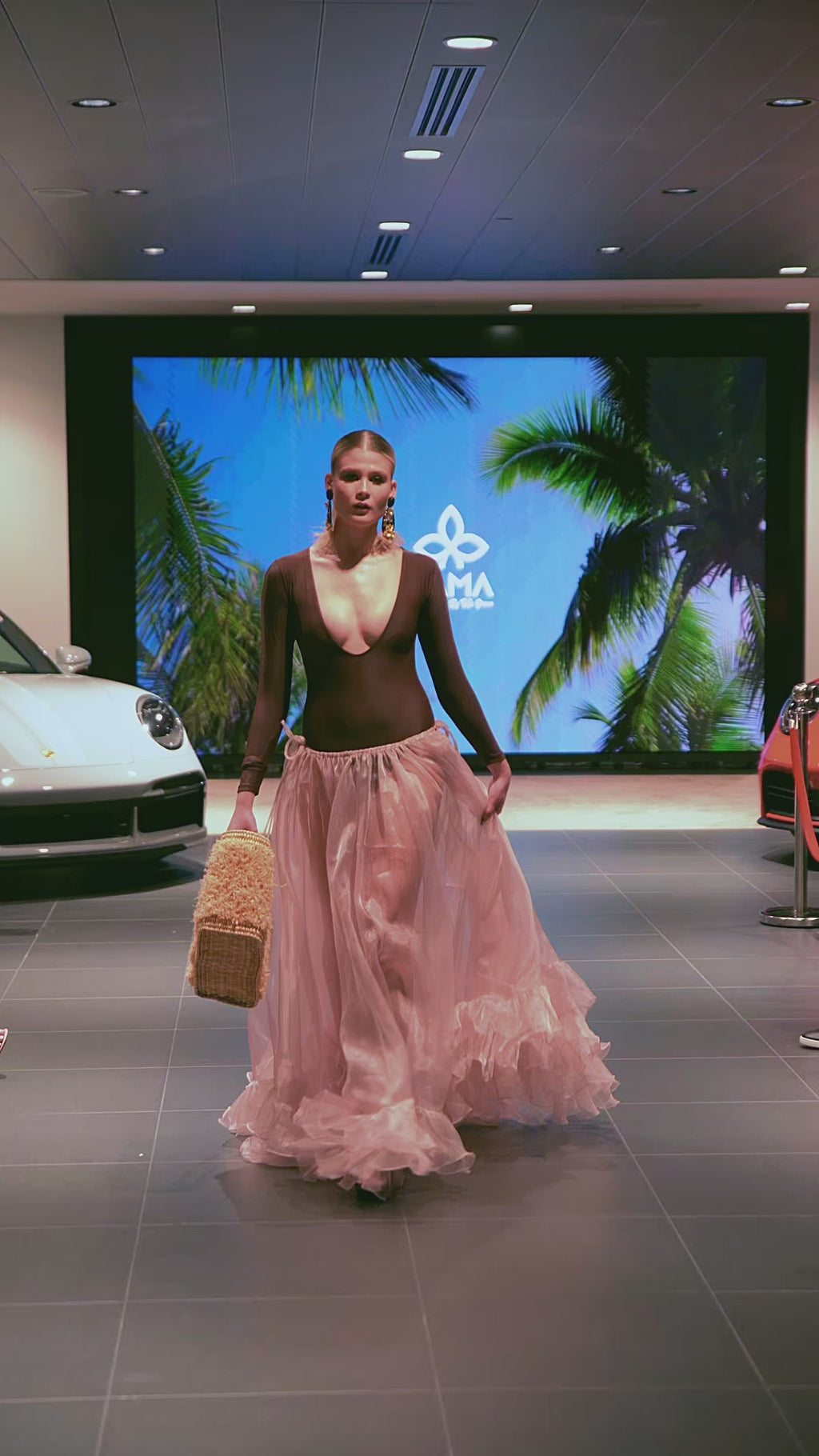 Model carrying Iraka Leather Beach Bag down the runway, showcasing its voluminous fiber texture and structured leather details