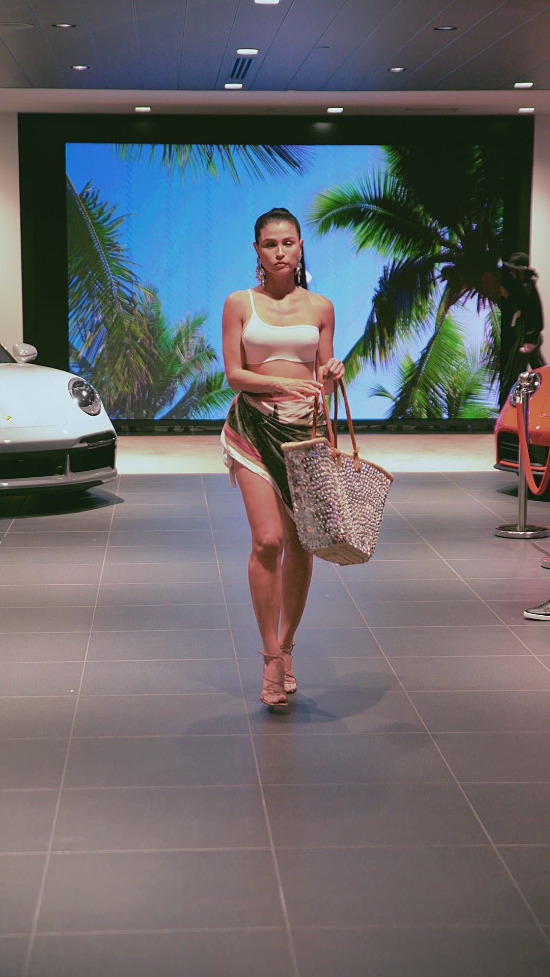 Runway model presenting the Silver Lentejuelón Bag with shimmering silver sequins and natural fiber construction